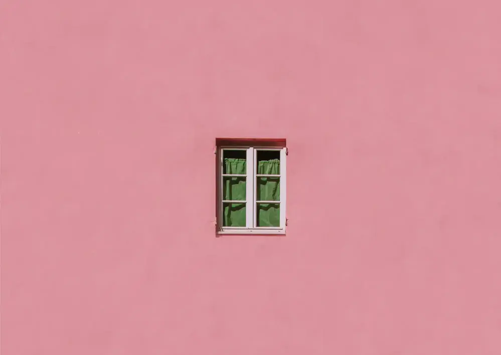 Dämpad rosa fasad med ett fönster i mitten
